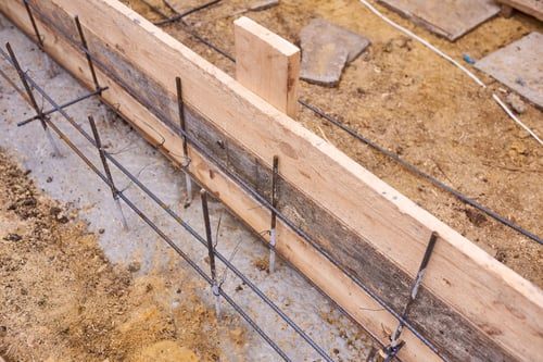 Formwork and reinforcing steel set for a concrete retaining wall footing